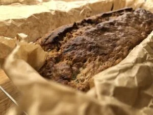 Banana bread coming from oven on parchment paper